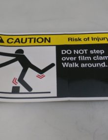 31006337 - LABEL CAUTION 'DO NOT STEP OVER FILM CLAMPS.'